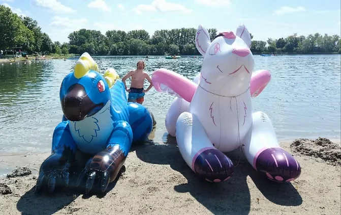 Zwei große aufblasbare Tiere bei einer Veranstaltung am See